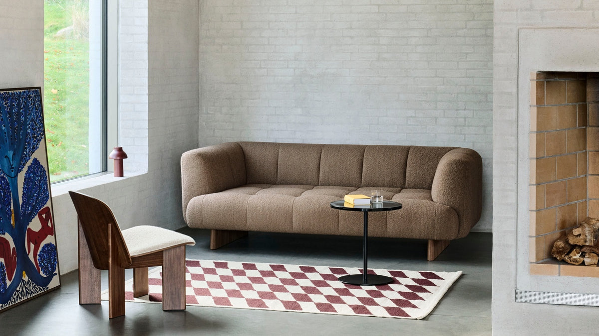 HAY sofa, rug and coffee table arranged together in a living room.